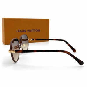 Lunettes de soleil de luxe de forme ronde Louis Vuitton pour femme avec verres dégradés marron, branches à motif écaille de tortue et charnières dorées ornées du logo LV, posées à côté de leur boîte de présentation orange.
