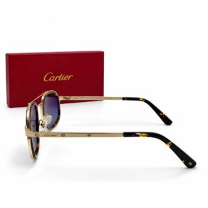 Lunettes de soleil Cartier Santos pour homme avec monture fine en métal doré et cercles en acétate écaille de tortue, branches élégantes gravées des vis signature Cartier avec embouts foncés, présentées à côté de leur boîte rouge de luxe Cartier.